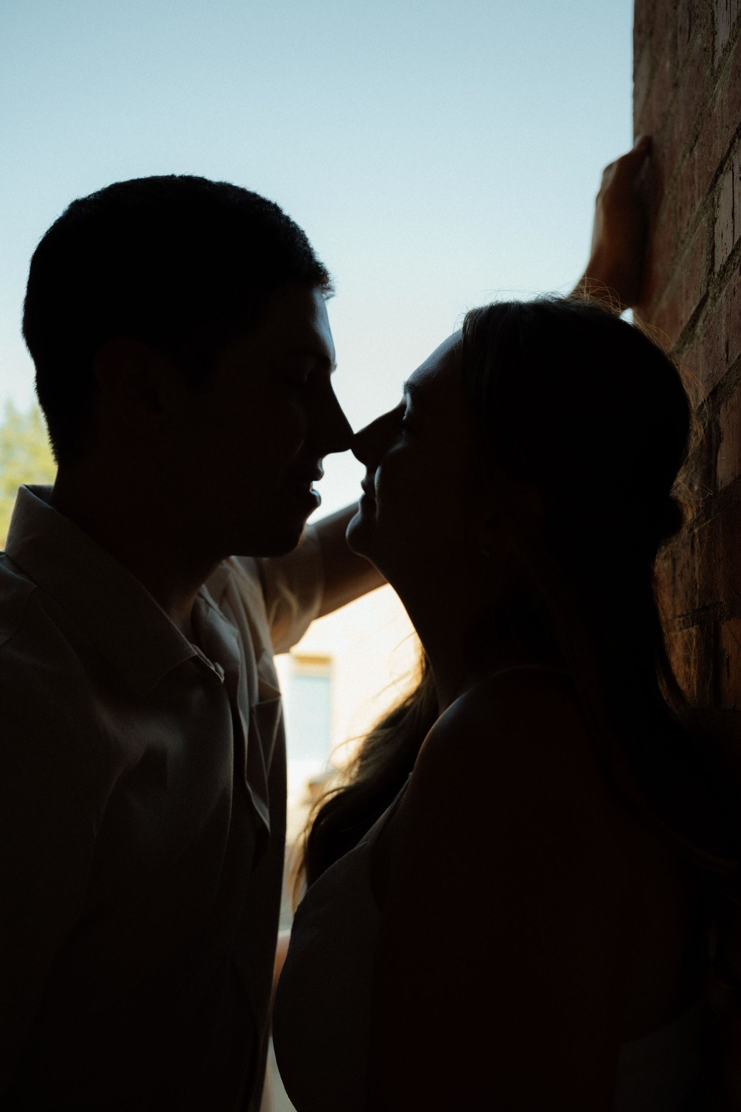 Silhouettes of a couple sharing an intimate moment at sunset.