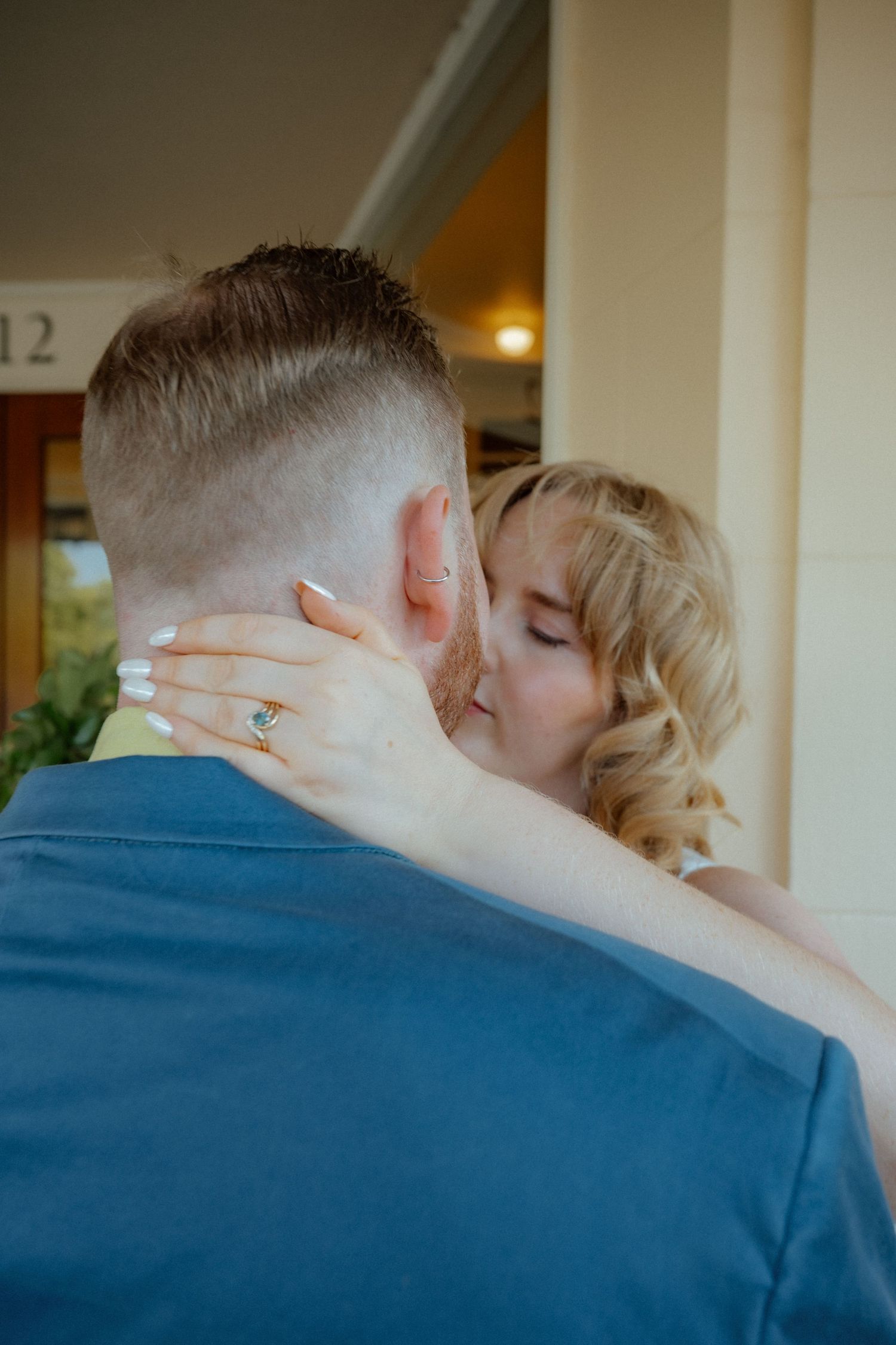 Intimate moment captured between couple in blue and light colored clothing.