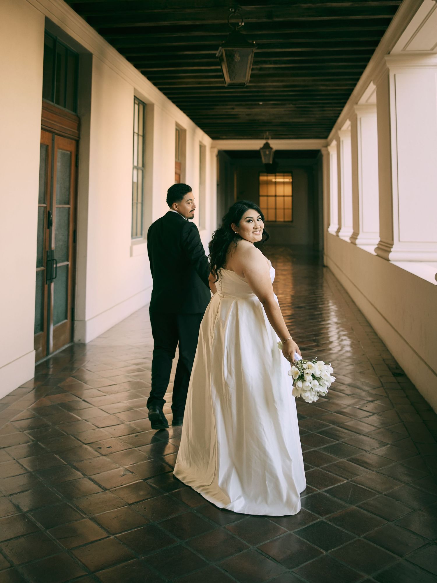 Elegant Pasadena City Hall wedding portraits in glowing covered hallway light. Book your session.
