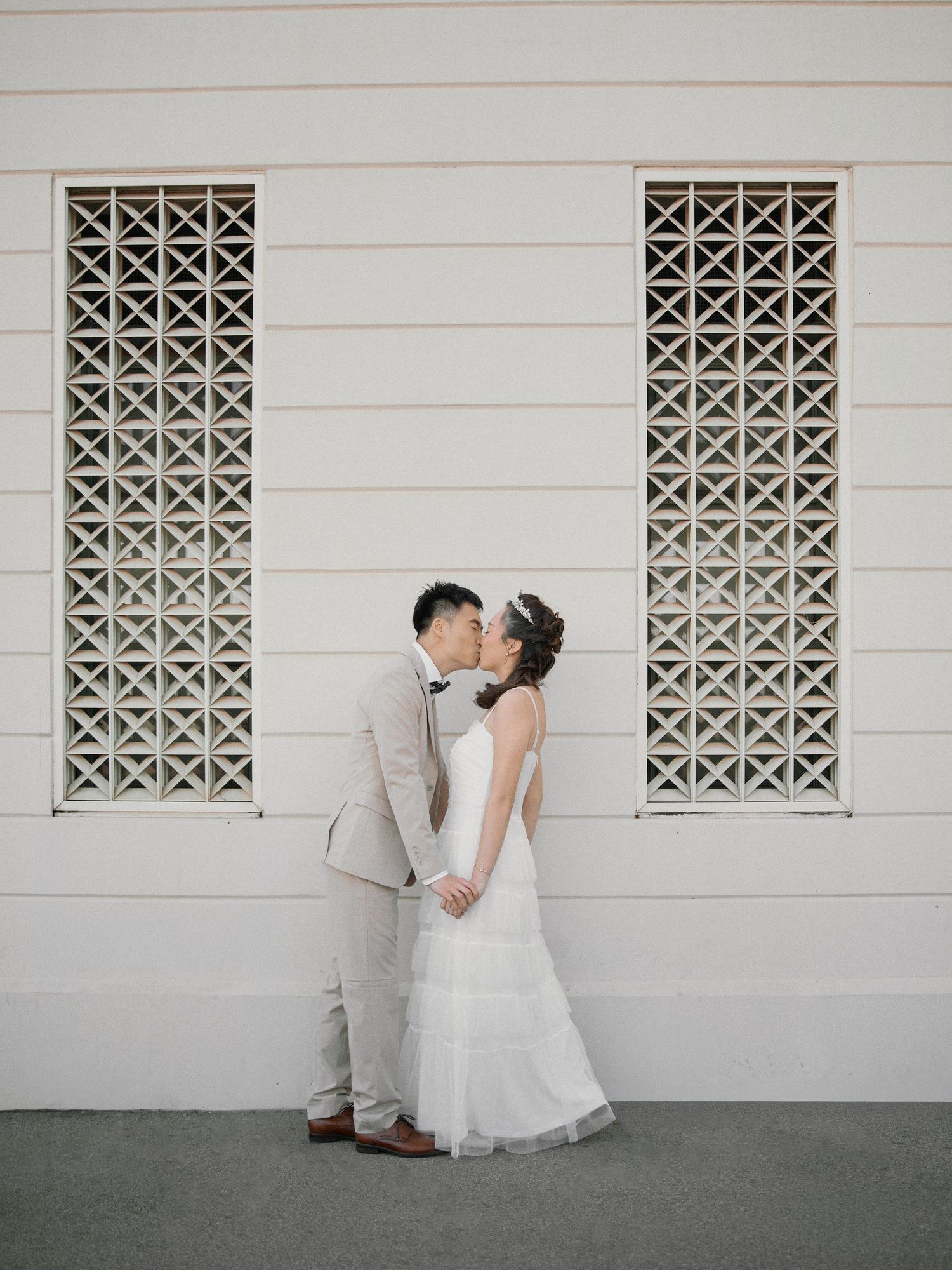Romantic engagement photo session featuring a couple posing against Art Deco stone walls at Griffith Observatory.