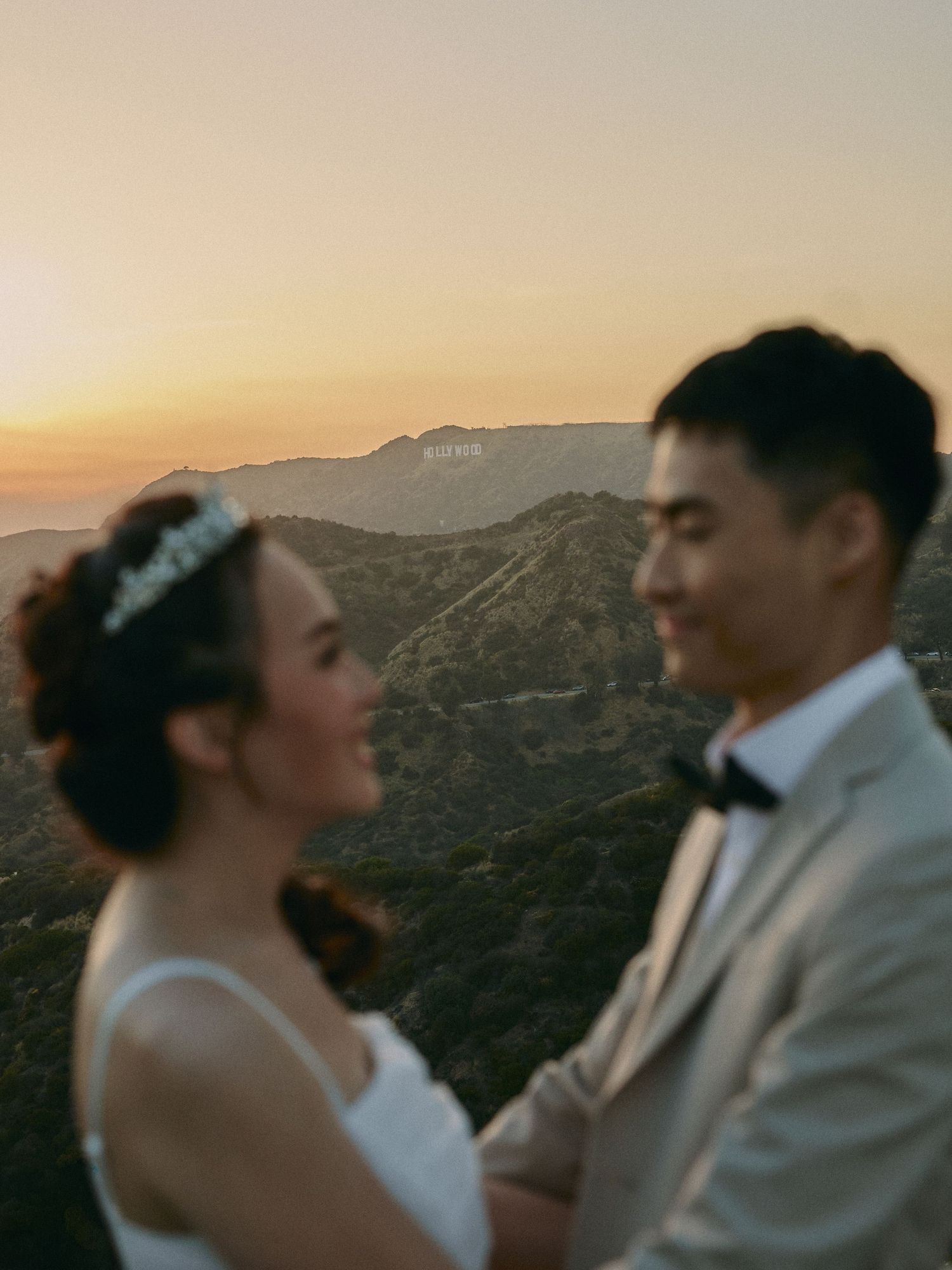 Sunset engagement portrait of a bride and groom overlooking the Los Angeles skyline from Griffith Observatory.