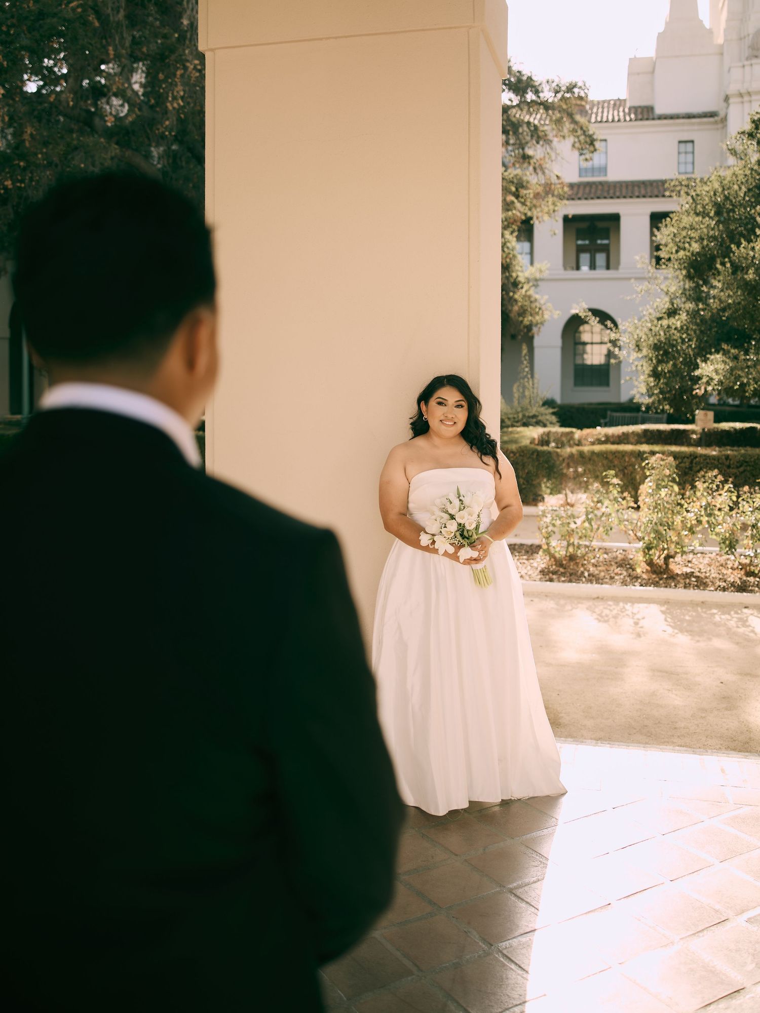 Pasadena City Hall wedding photographer capturing groom admiring bride in courtyard. Book your SoCal session.