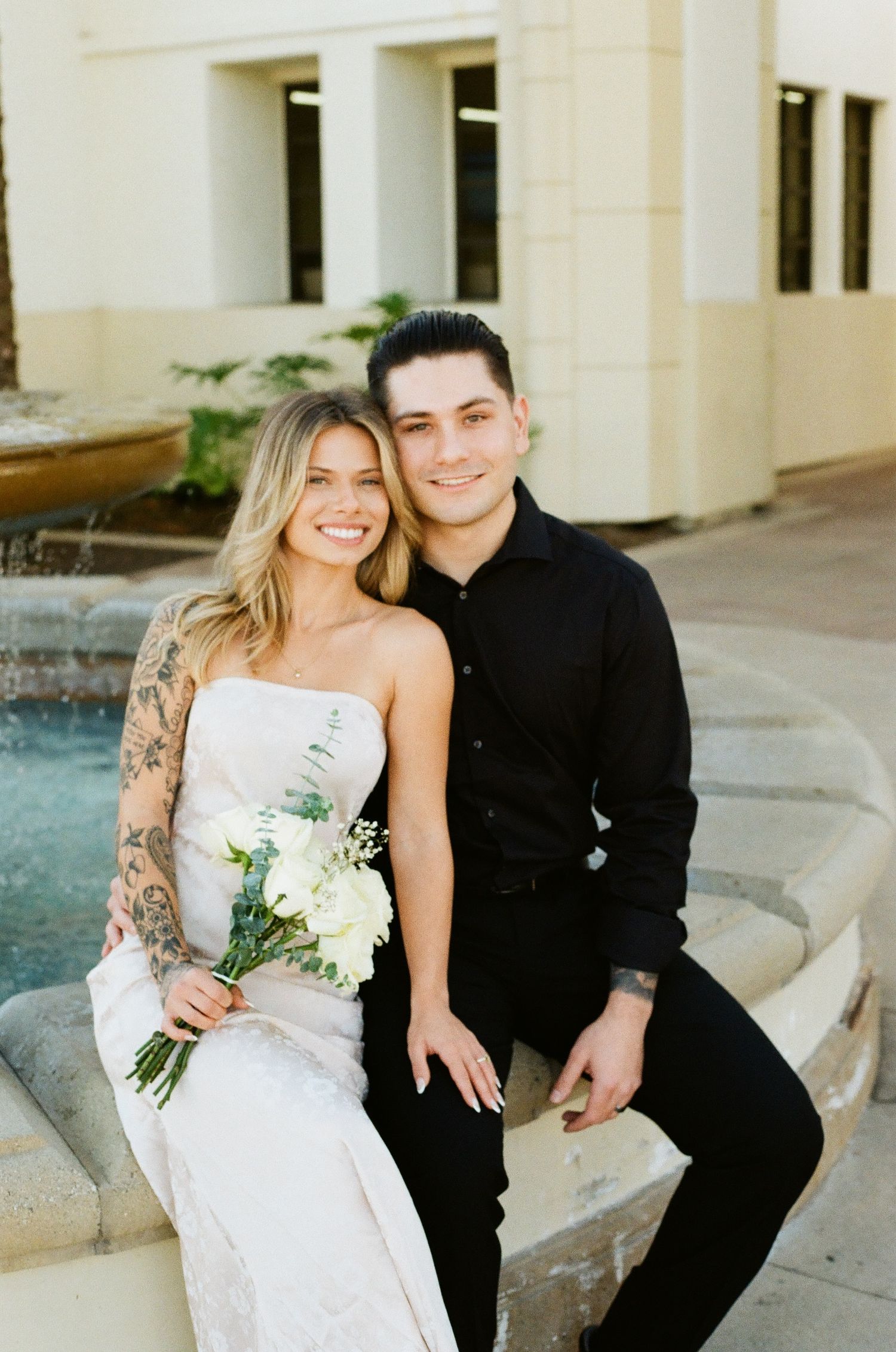 Modern bride and groom posing on stone steps for intimate Laguna Hills elopement portraits.