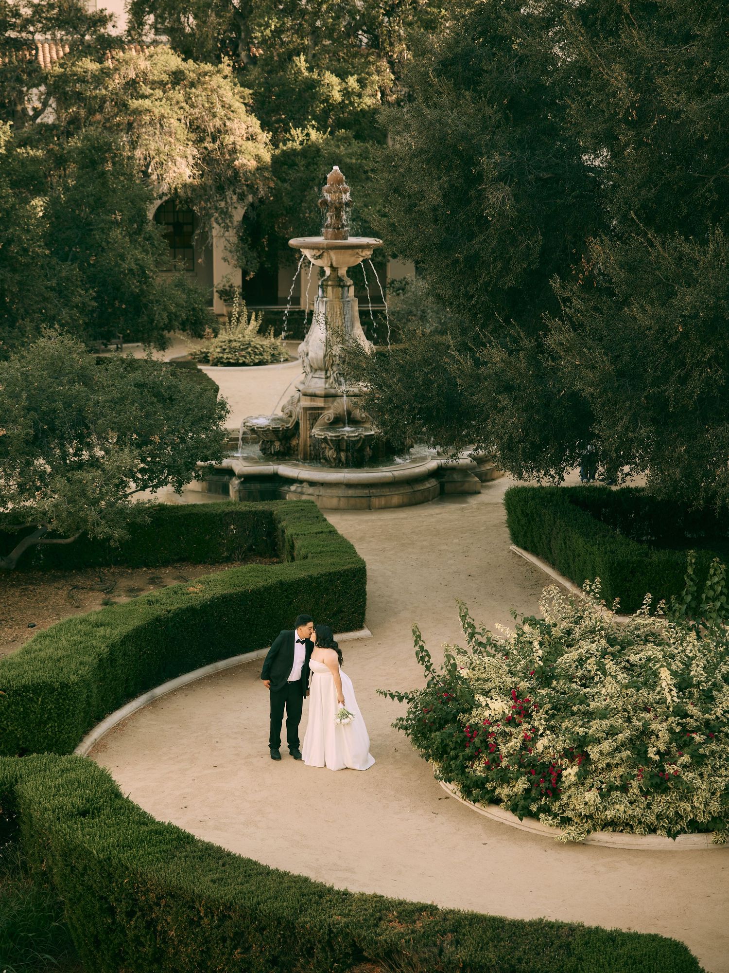 Pasadena City Hall wedding photographer capturing bride and groom walking through lush courtyard gardens.