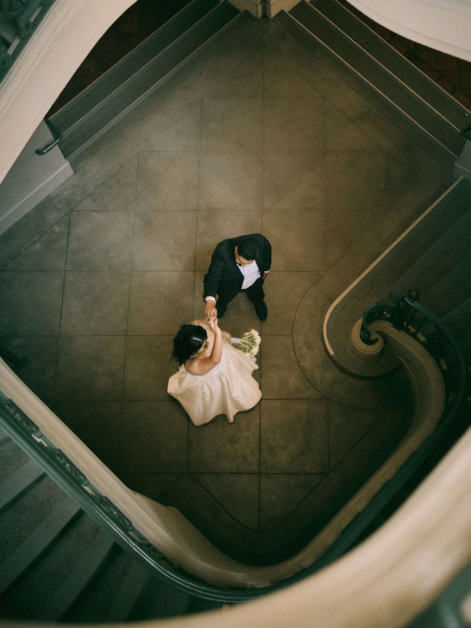 High-angle overhead portrait of wedding couple on spiral staircase at Pasadena City Hall. Book now.