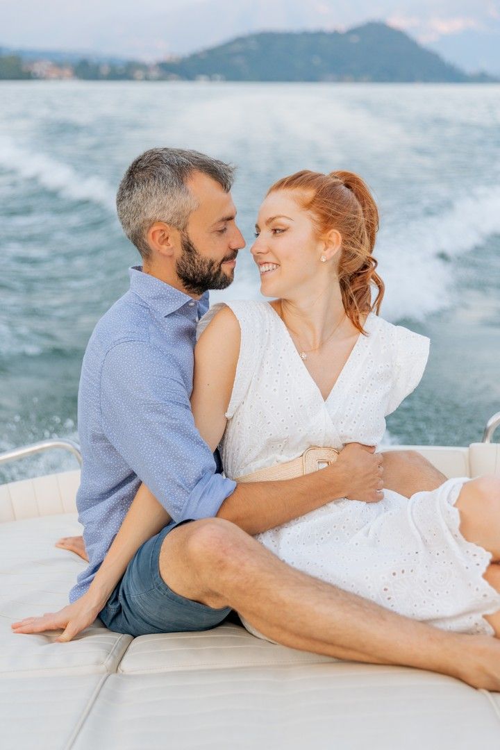 Intimate boat photoshoot with mountain lake and coastal scenery in the background.