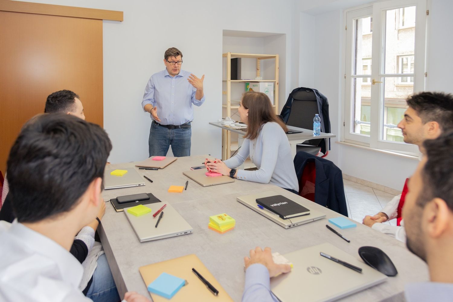 Business professionals collaborating around a table in a bright modern office space.