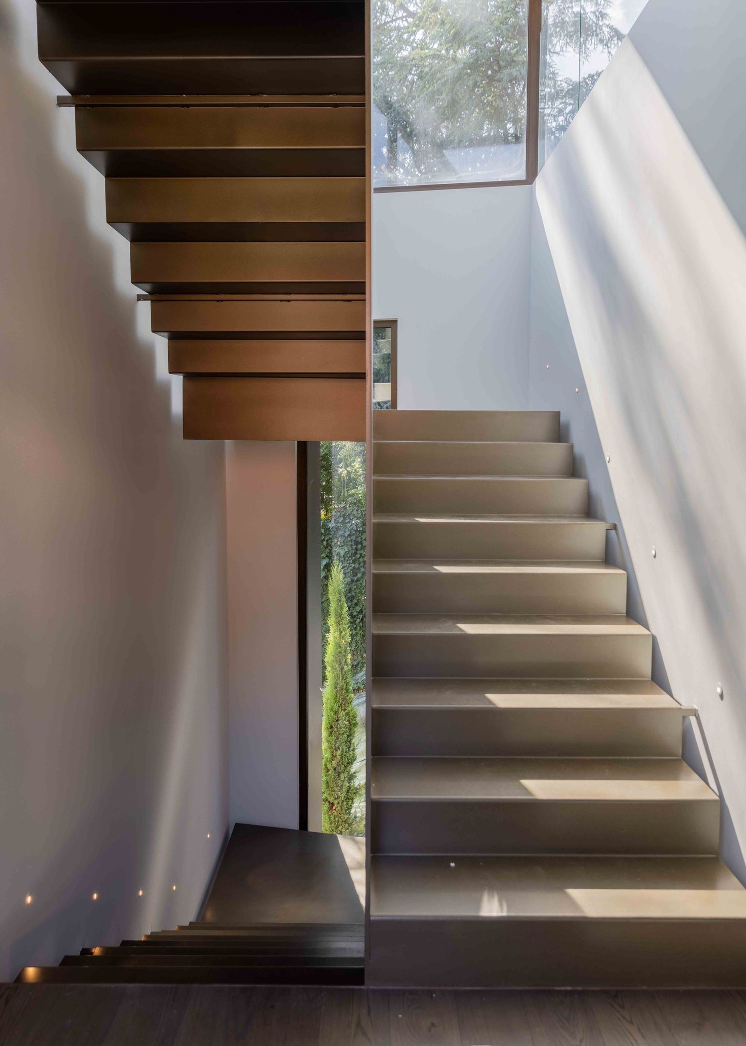 Modern interior staircase with dramatic lighting and sleek metal railings.