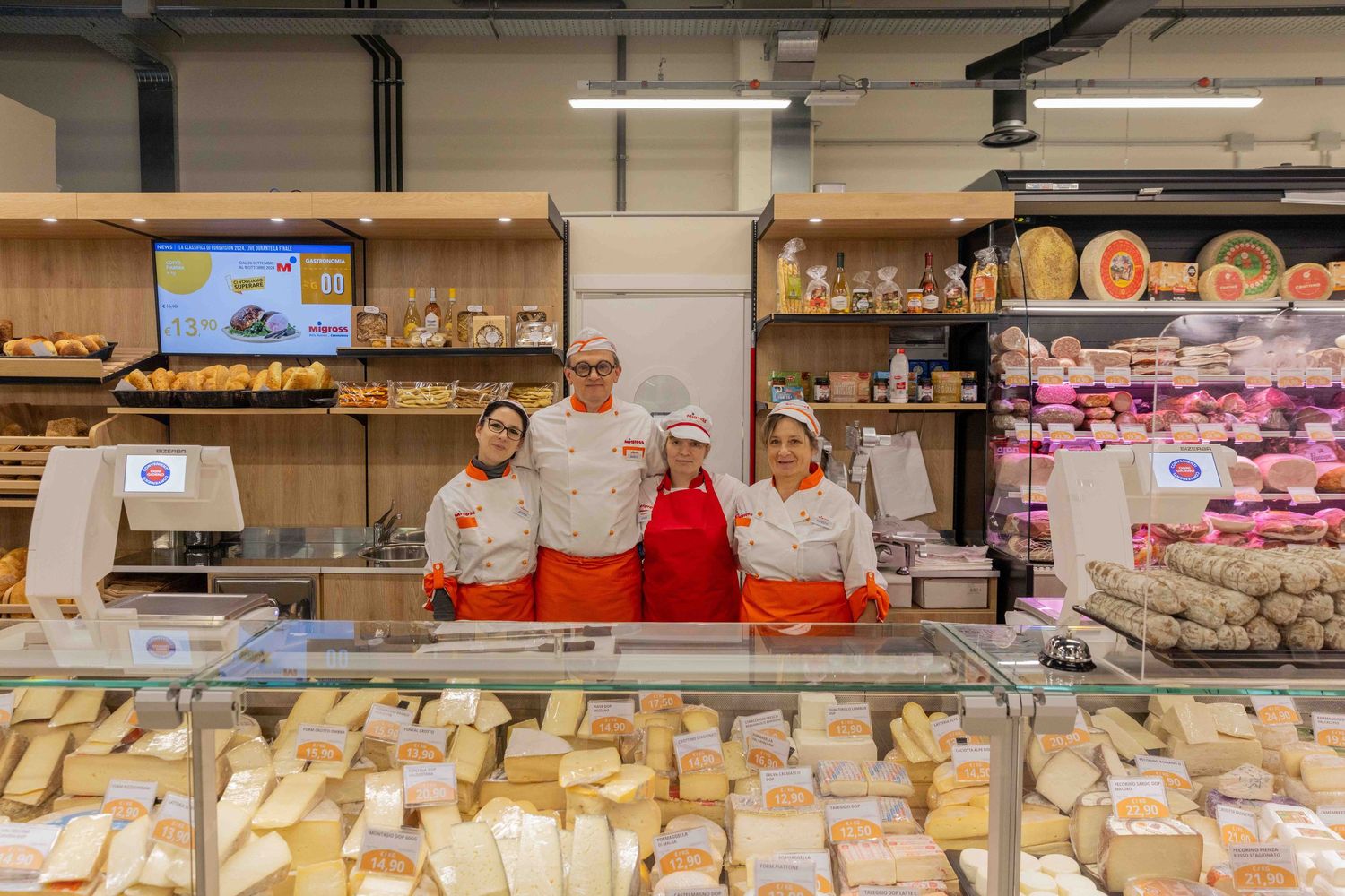 Deli counter with extensive cheese and meat selection on display.