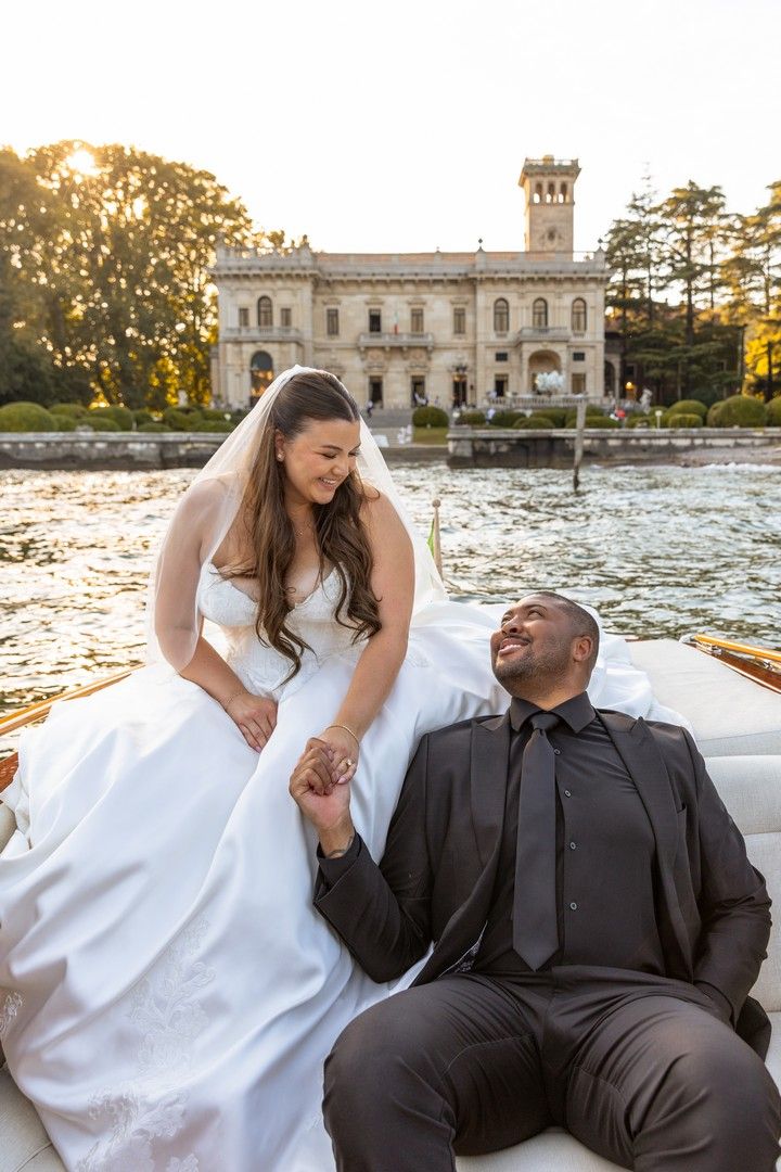 Romantic boat ride along a historic waterfront villa during golden hour.
