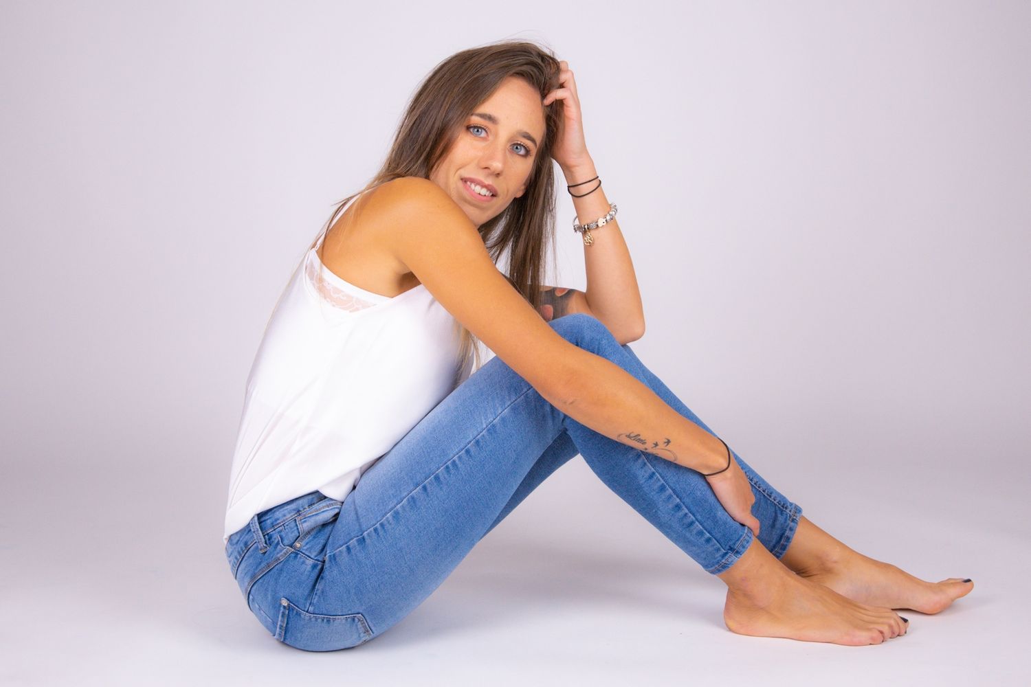 Casual lifestyle portraits in jeans and white top against studio background.