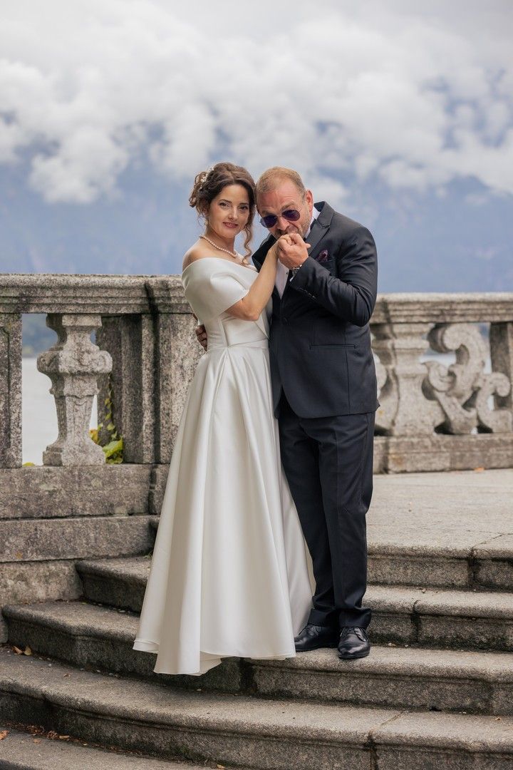 Newlyweds sharing intimate moments on historic stone steps by Lake Como.