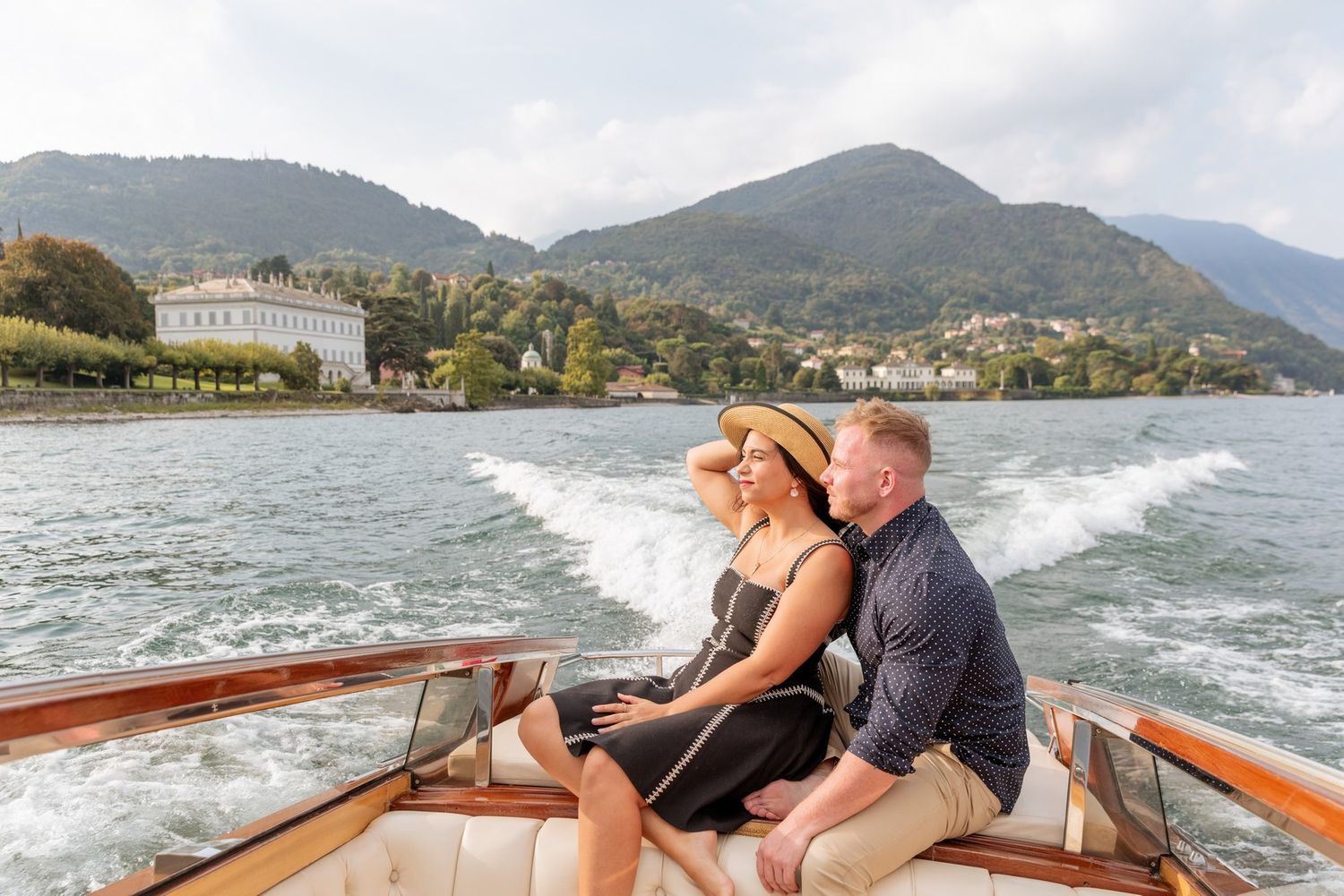 Speed boat cruising across a mountain lake with elegant waterfront properties in view.