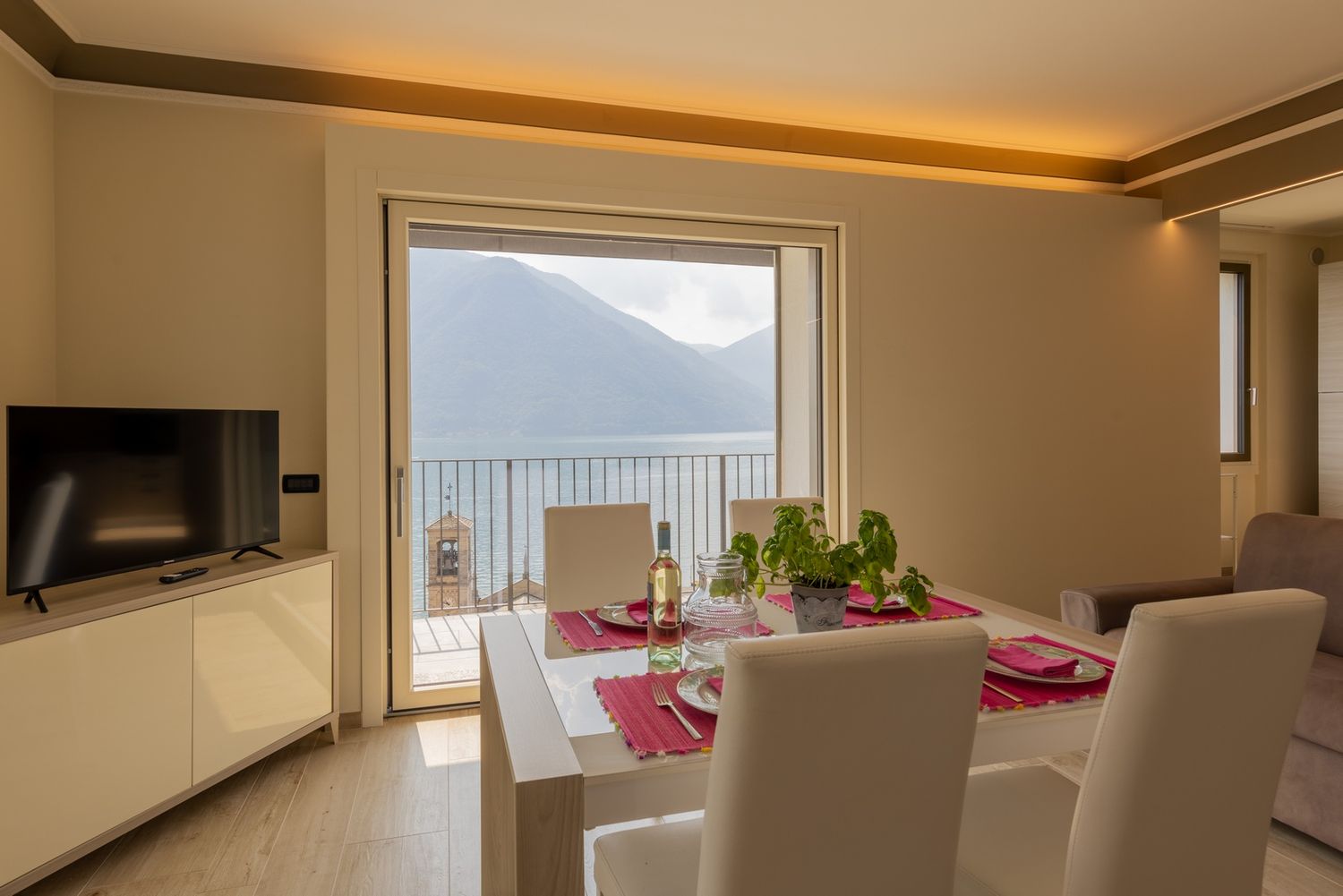 Modern apartment interior with panoramic mountain views and ambient lighting.