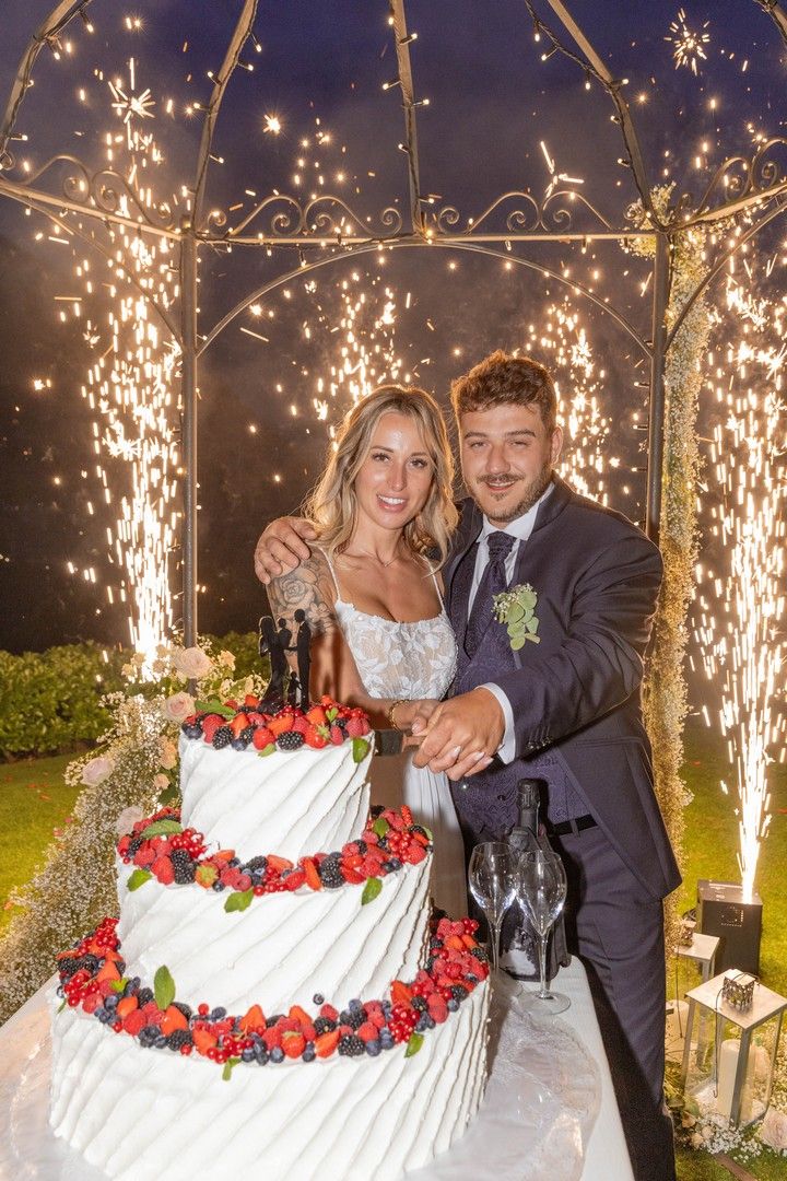 Wedding cake cutting ceremony with sparklers creating a magical nighttime atmosphere.
