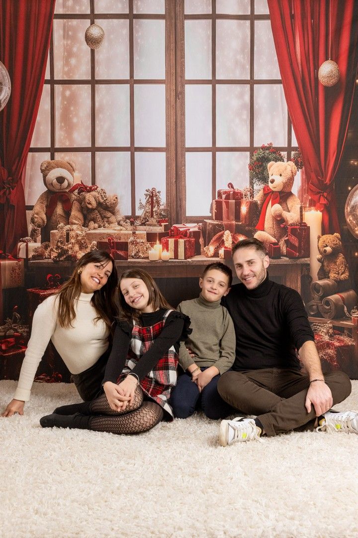 Holiday photo setup with red curtains and Christmas decorations on white carpet.