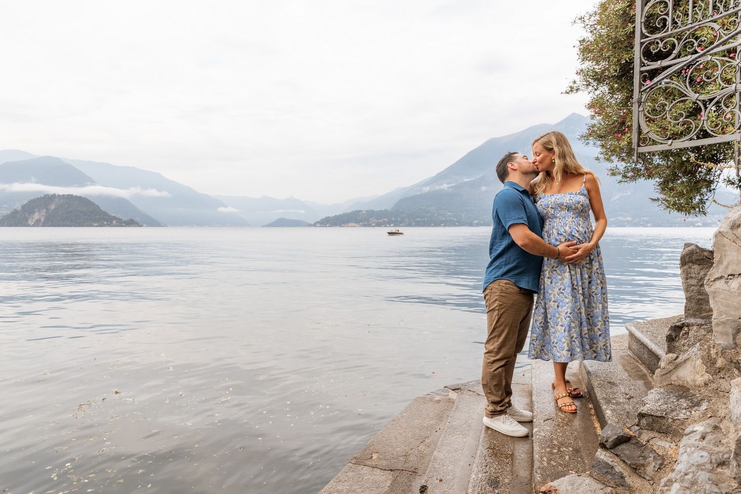 Romantic lakeside photo session with mountain views and ornate gates.