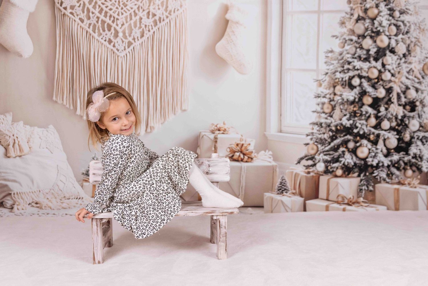 Minimalist Christmas photo setting with macrame decor and flocked tree.
