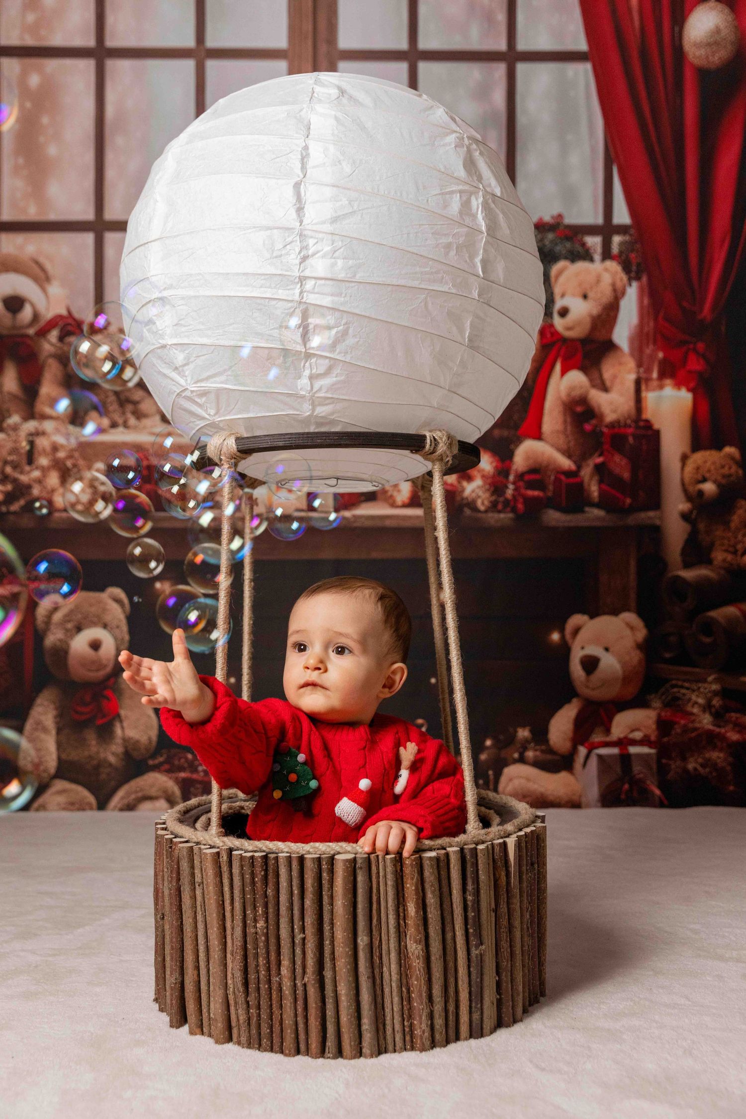 Cozy Christmas setup with a round paper lantern and teddy bears in the background.