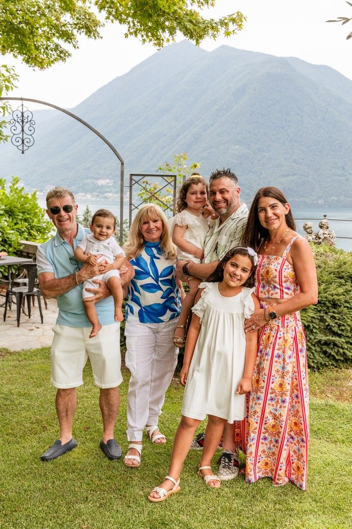 Group photo session in a garden setting with mountains and lake in the background.