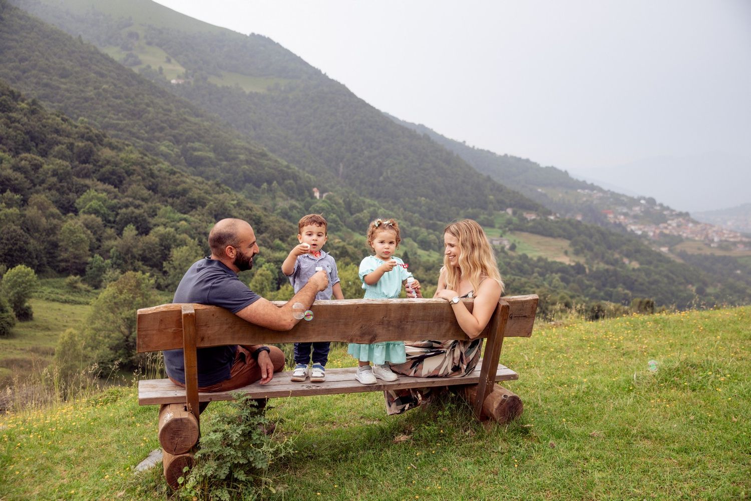 Family gathering at a rustic outdoor seating area with scenic mountain views.