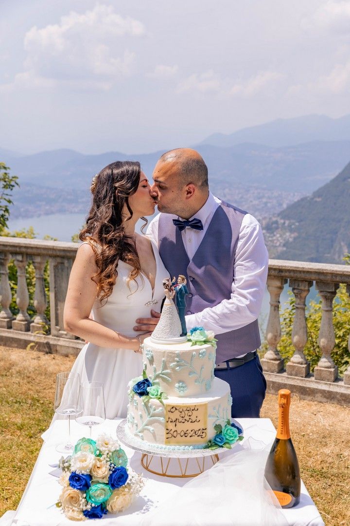 Wedding couple sharing a romantic moment with their cake on a scenic mountain overlook with stunning views.