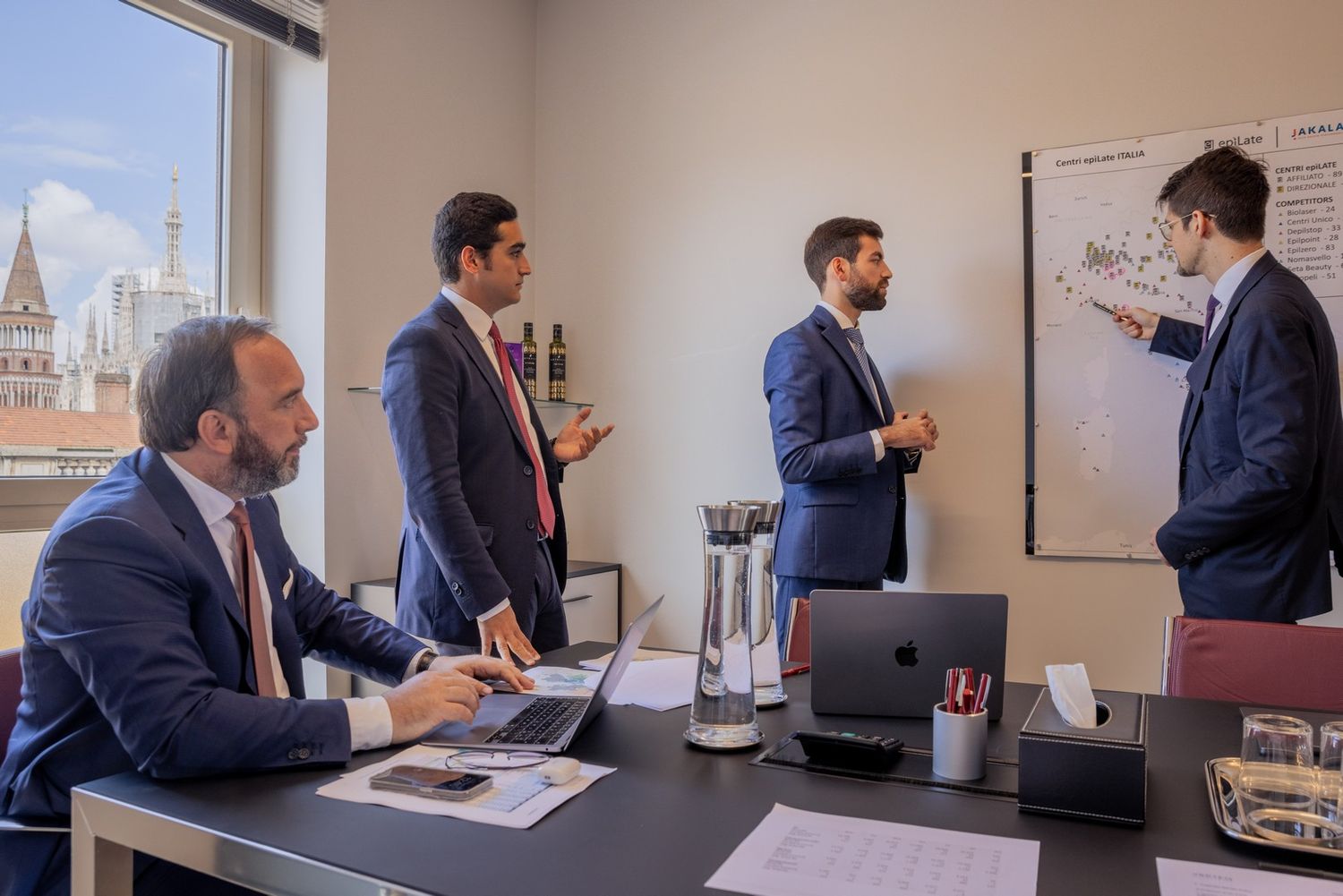 Business professionals working together in a modern office setting with city views.