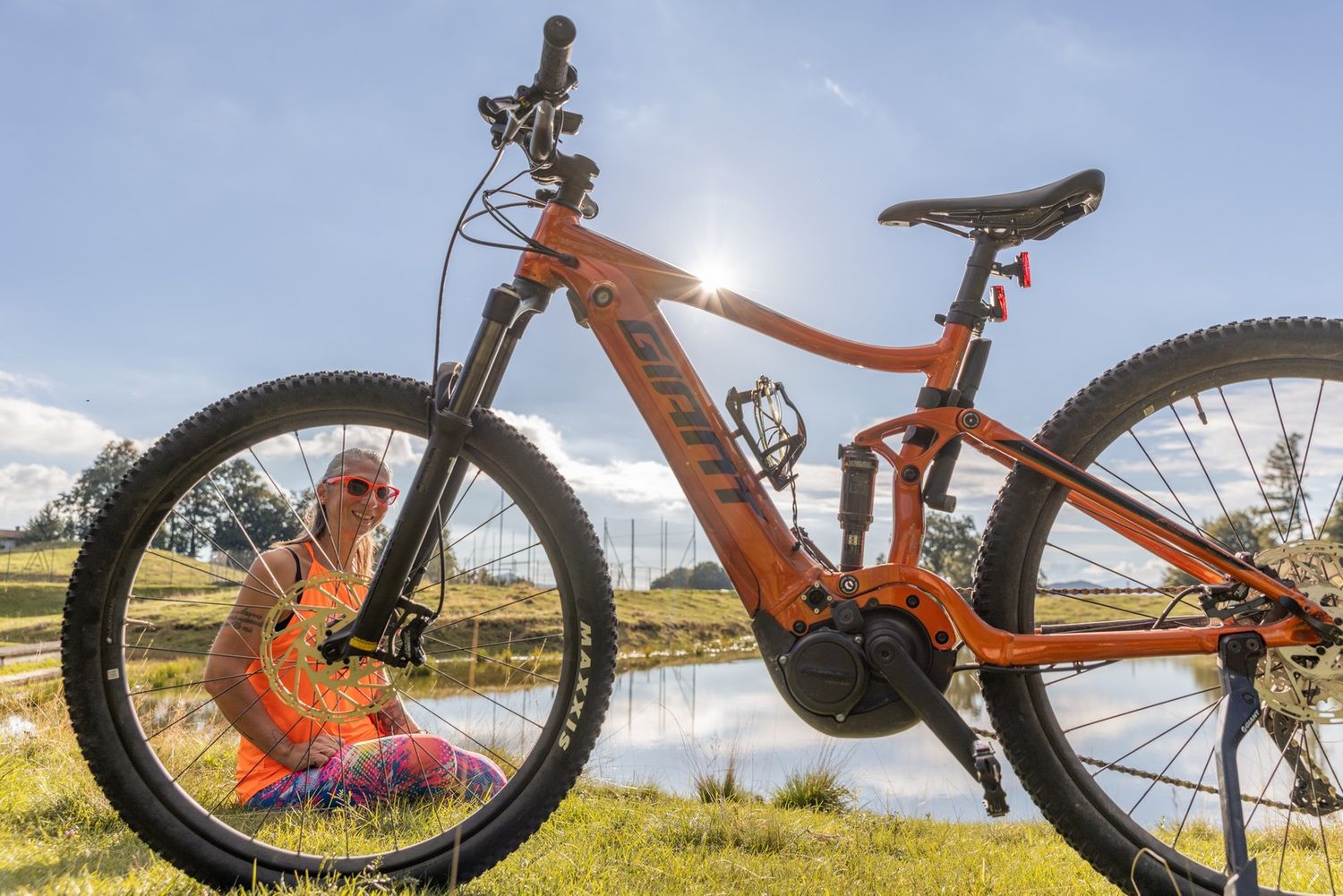 Close-up shots of an orange mountain bike against natural outdoor backdrop.