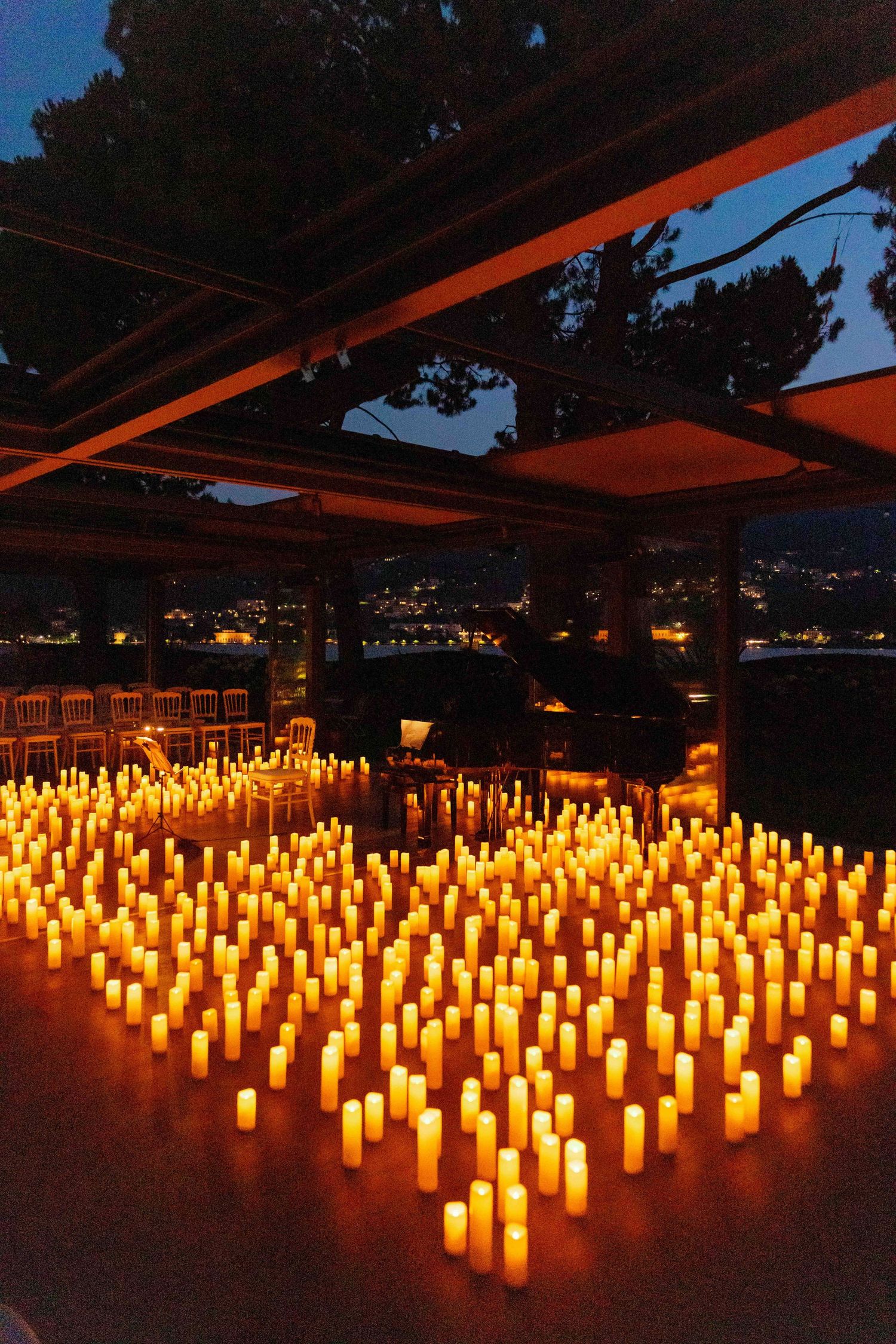 Hundreds of glowing candles create a romantic ambiance on an outdoor terrace at night.