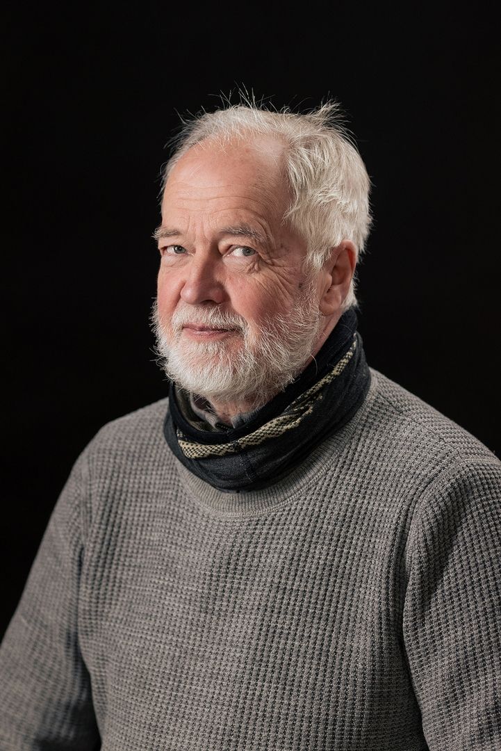 Portrait series showing a senior man in a gray sweater and black scarf against dark background.