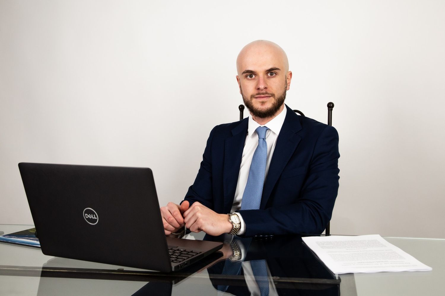 Business professional working on a Dell laptop at a white desk.