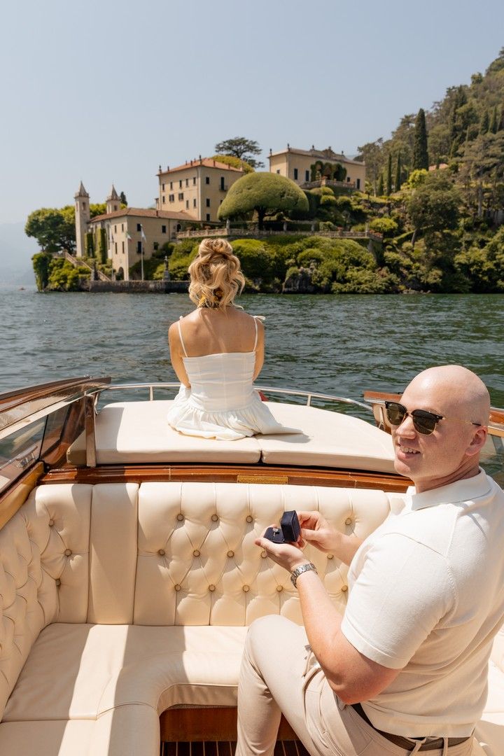 A luxury boat ride on Lake Como with Italian villas and cypress trees lining the mountainous shoreline.