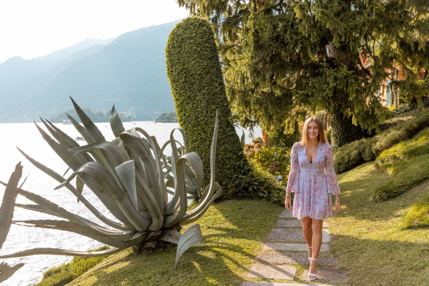 Garden pathway with mountain lake views and decorative plants.