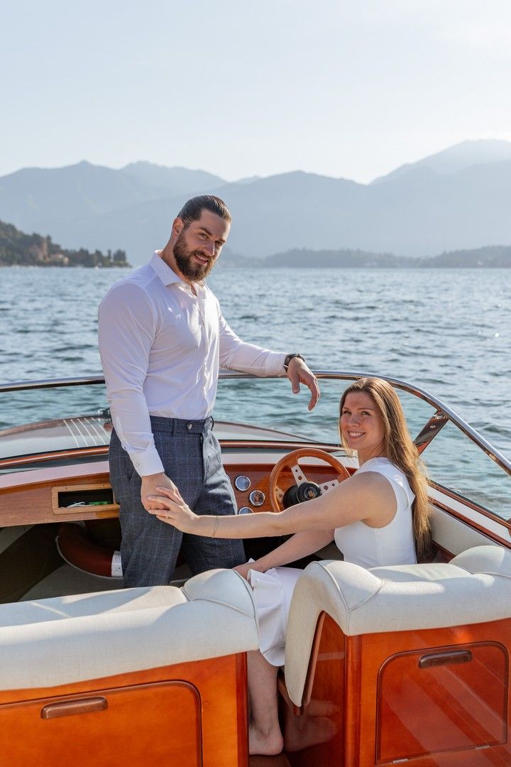 Classic wooden speedboat cruise with stunning mountain lake scenery on a sunny afternoon.