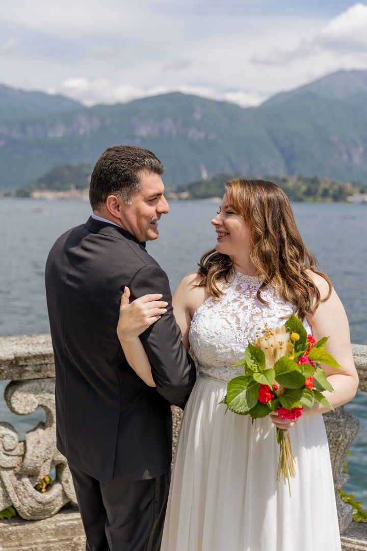 Happy wedding couple sharing joyful moment by scenic mountain lake.