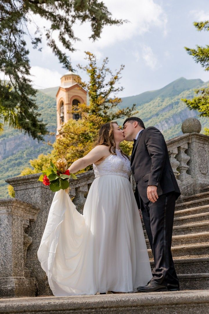 Wedding photography on historic stone steps with mountain views and architecture in the background.