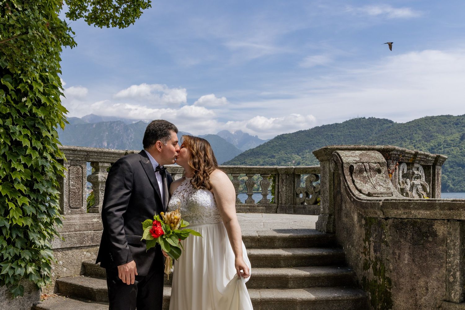 Stone balcony overlooking a scenic mountain lake view on a sunny day.