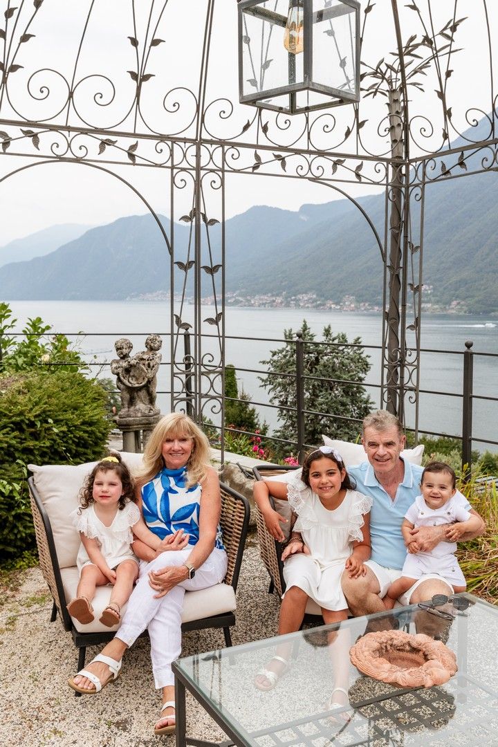 Family relaxing on outdoor furniture with scenic mountain lake views.