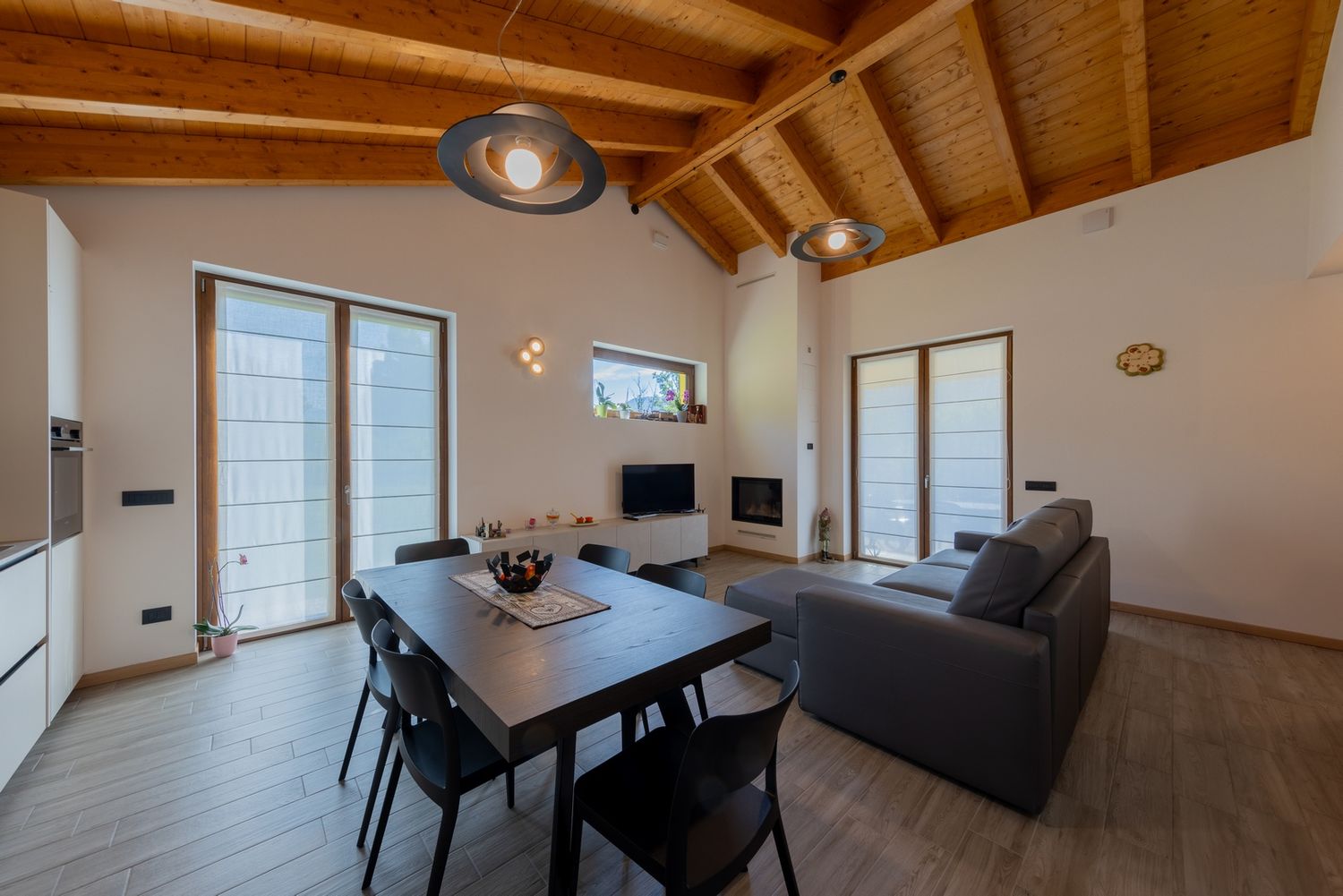 Interior of luxury home with exposed wooden beams and modern dining area.
