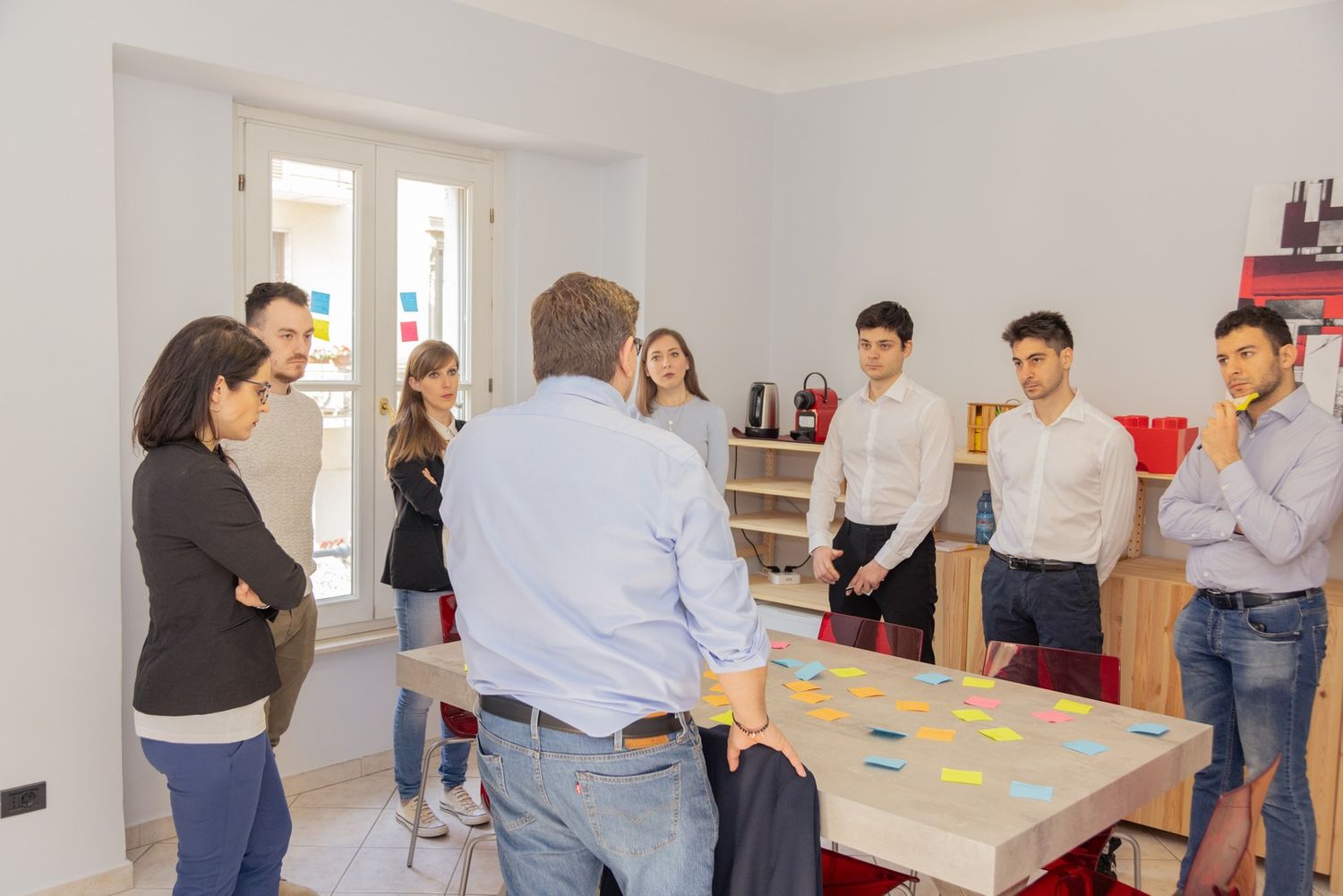 Team members engaged in a workshop activity with sticky notes on tables.