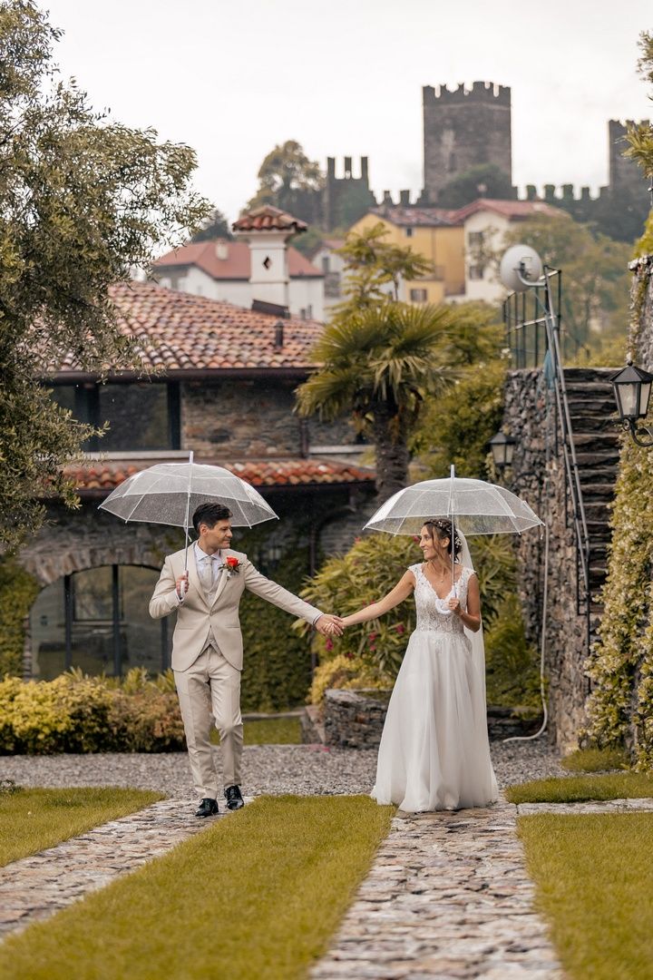 A playful wedding photo series with clear umbrellas in a castle garden setting.