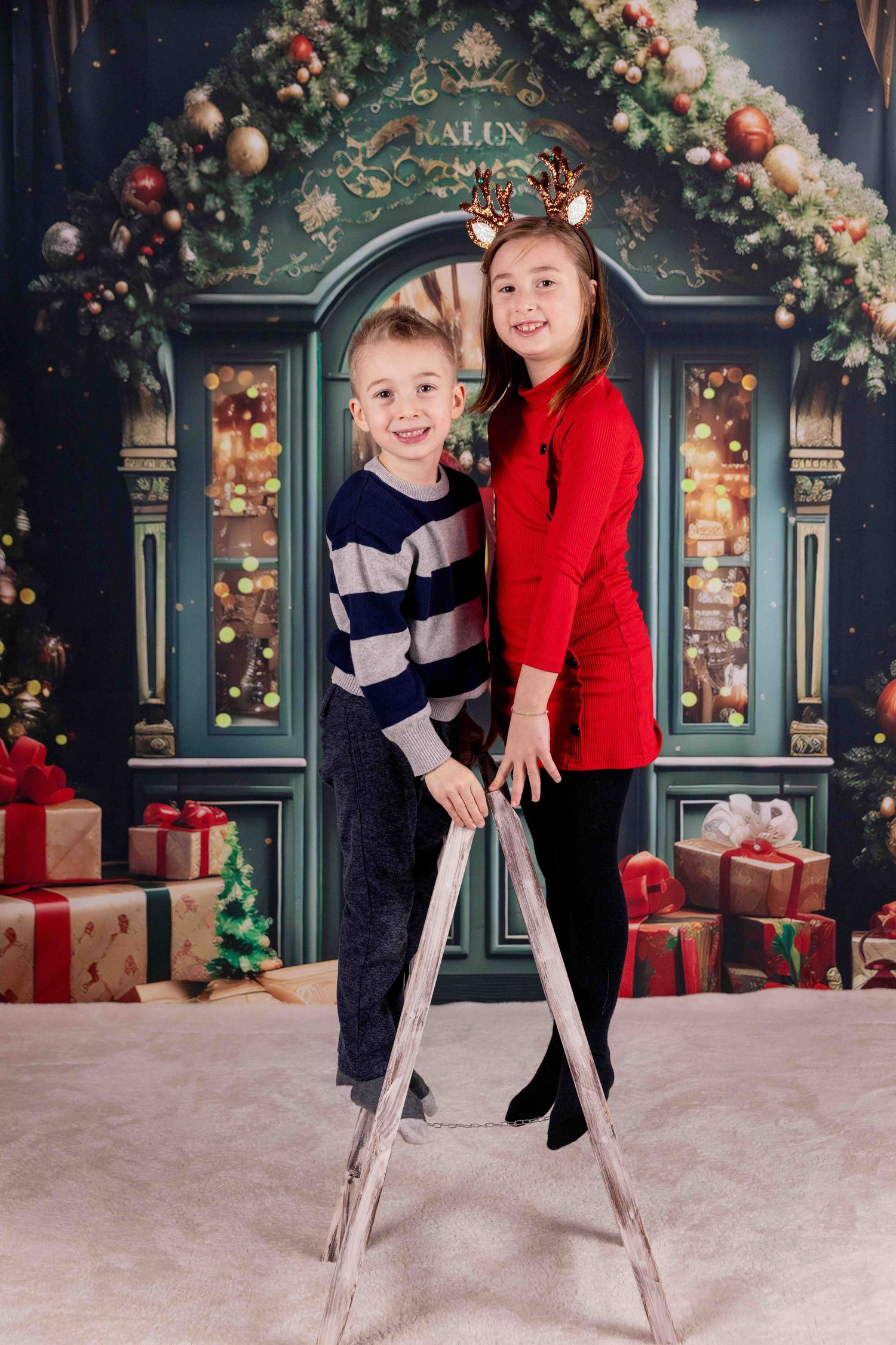 Children playing and jumping in front of vintage green salon door with Christmas decorations.