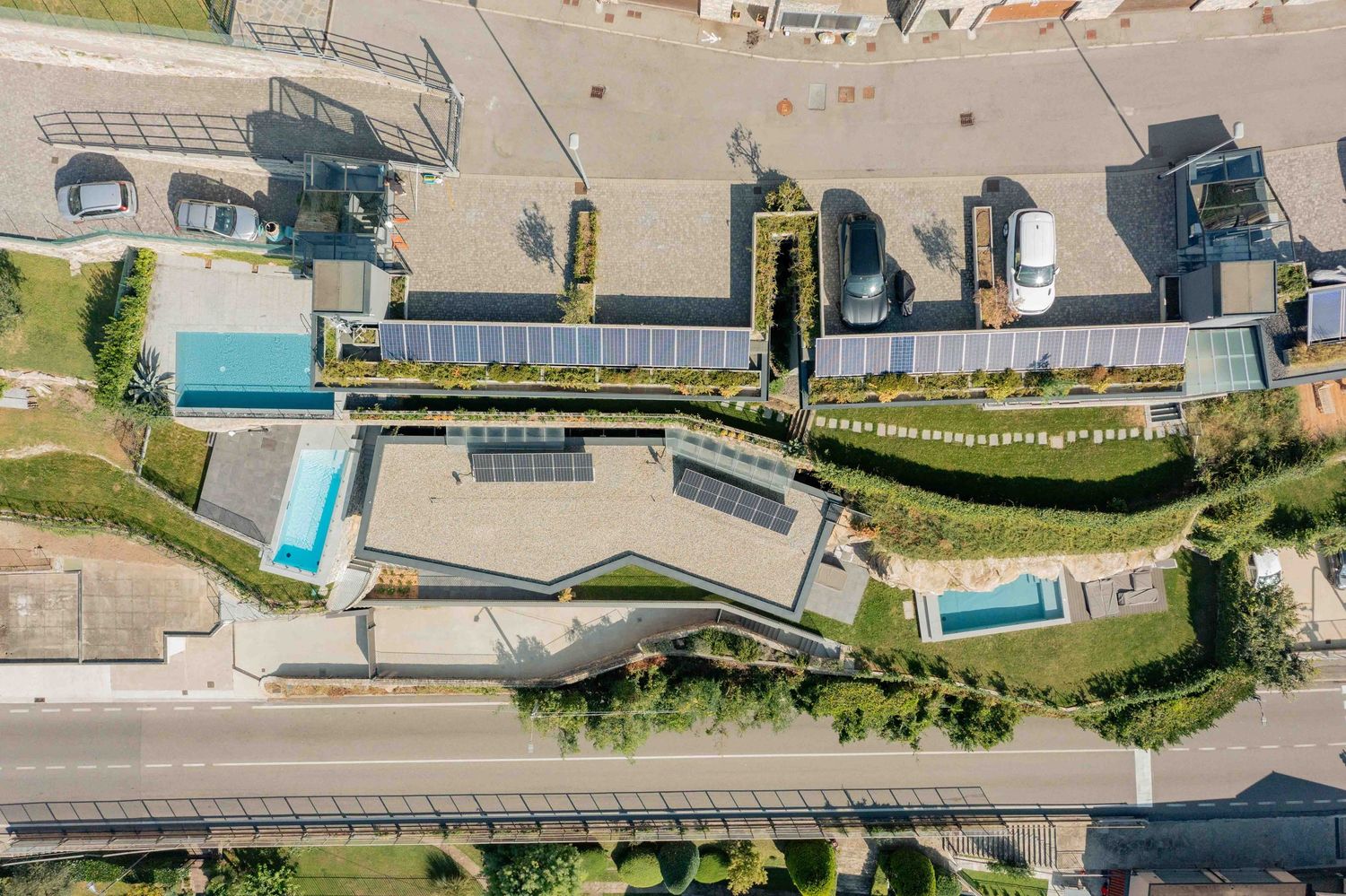 Bird's eye view of modern residential complex with pools and solar panels on rooftops.