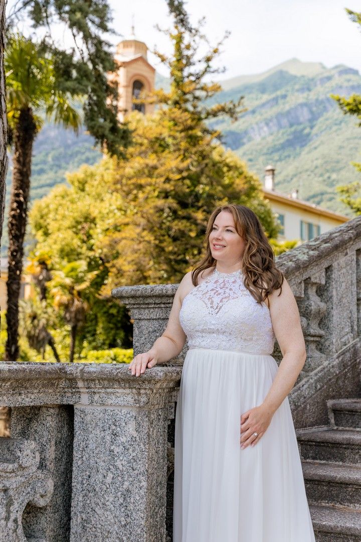 Elegant bridal portraits on stone steps with mountains and architecture in the background.