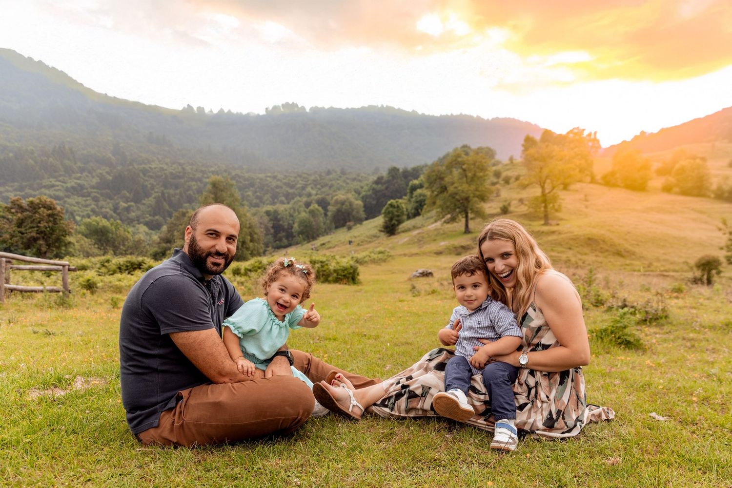 Family photoshoot during golden hour in a mountainous landscape.