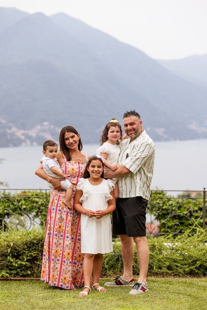Family gathering on a grassy overlook with lake and mountain views.
