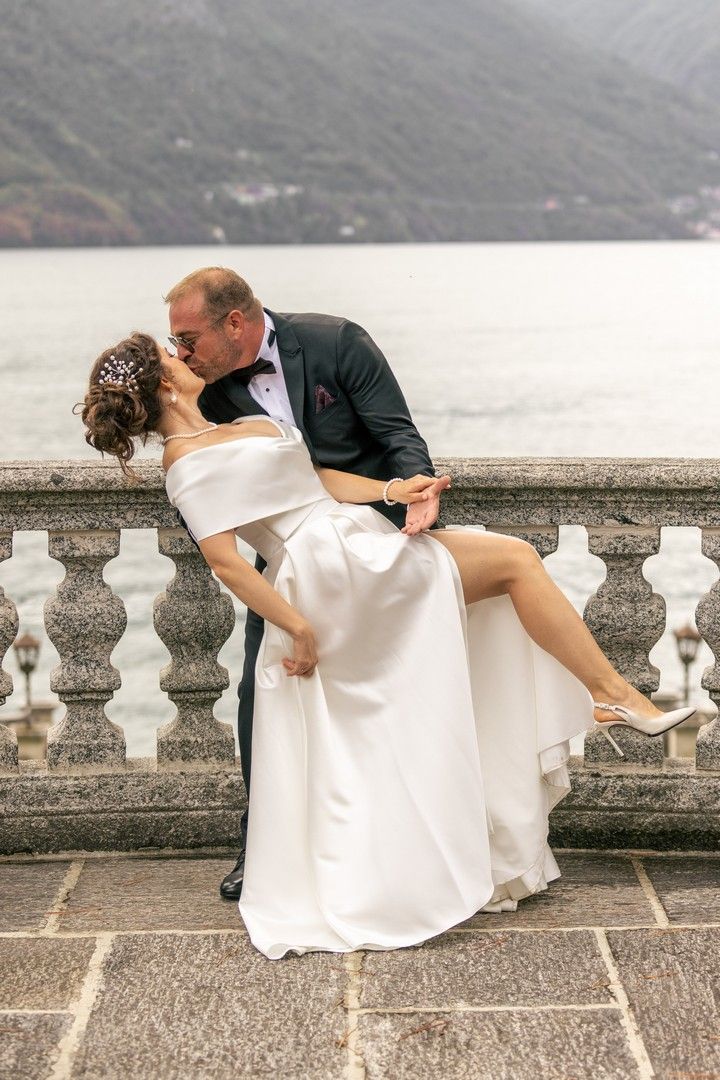 Romantic wedding dance dip pose against Lake Como's mountain backdrop.