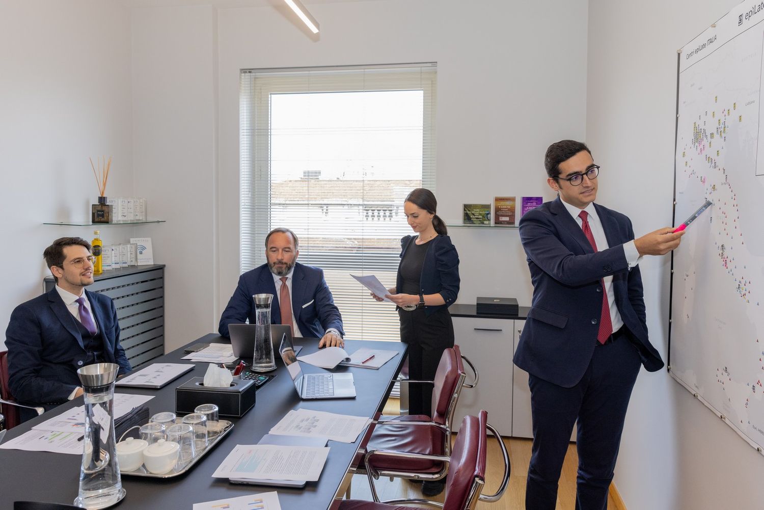 Business meeting in a bright office space with whiteboard presentations and team discussions.
