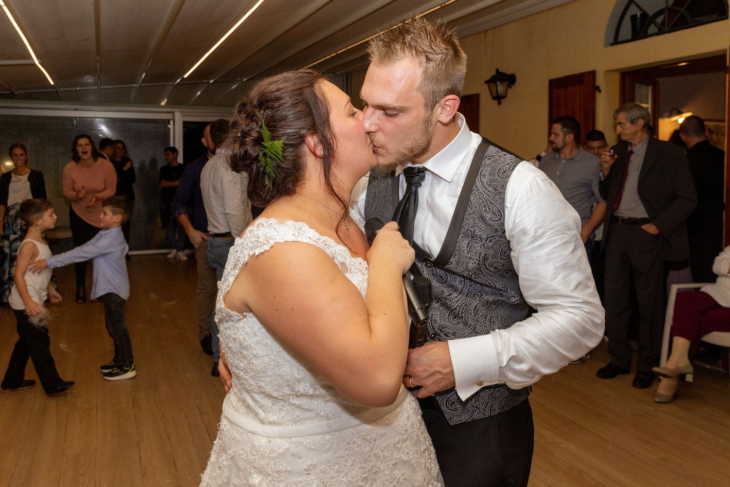 A couple shares a romantic dance together at a wedding reception in a banquet hall.