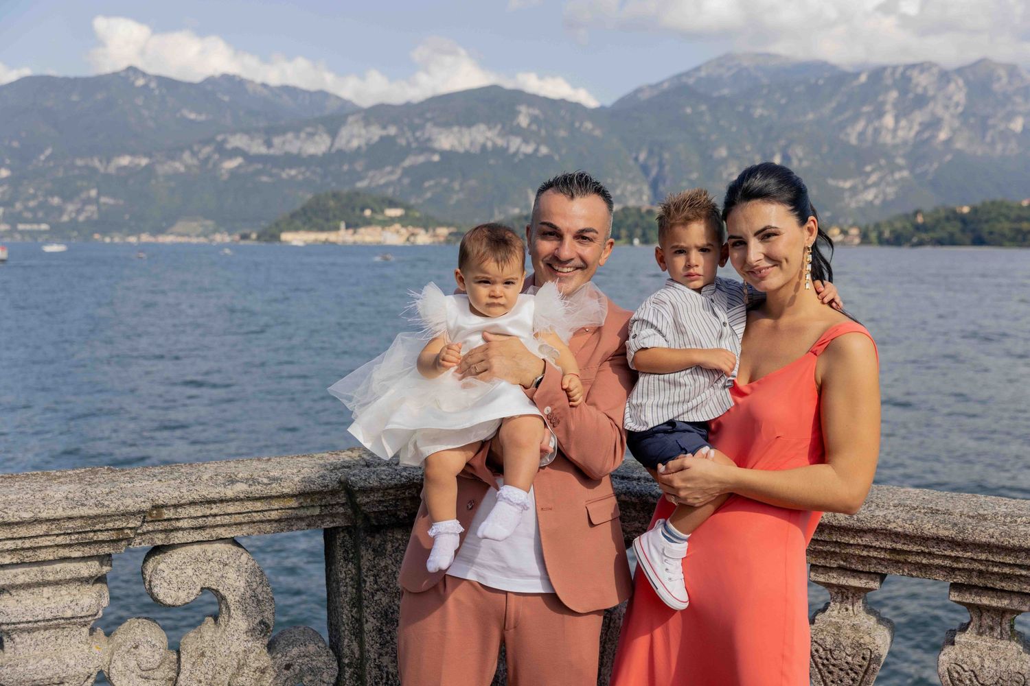 Family gathering on a lakeside terrace with mountains in the background.